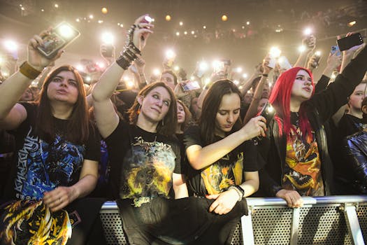 Fans enjoying a live rock concert, capturing moments with cell phones.