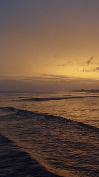 Peaceful ocean view at sunset with gentle waves and a warm sky.
