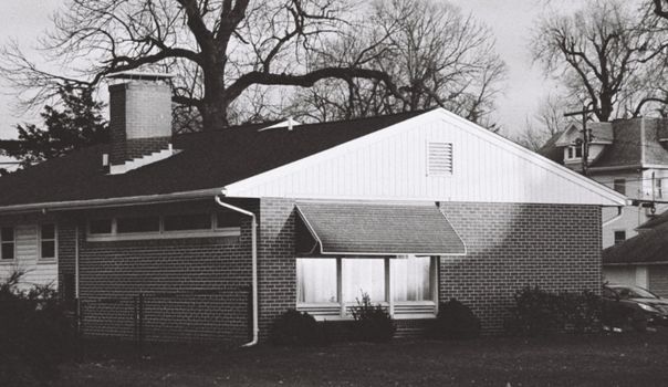 Black and white photo of a classic brick house in Clinton, IL during winter.