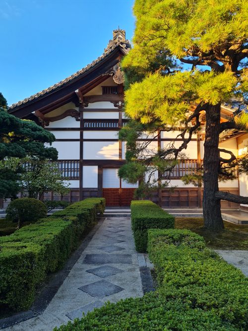 Free A peaceful Japanese Zen garden featuring traditional architecture amidst lush greenery. Stock Photo