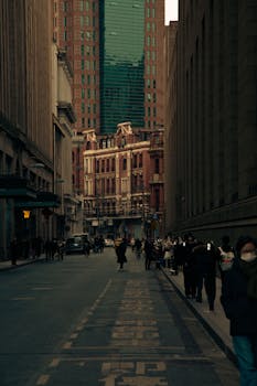 Atmospheric city street scene showcasing historic and modern architecture under a moody sky.