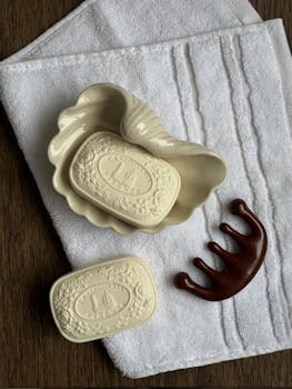 Top view of a decorative soap dish with soap on textured towels, styled for spa and home decor.
