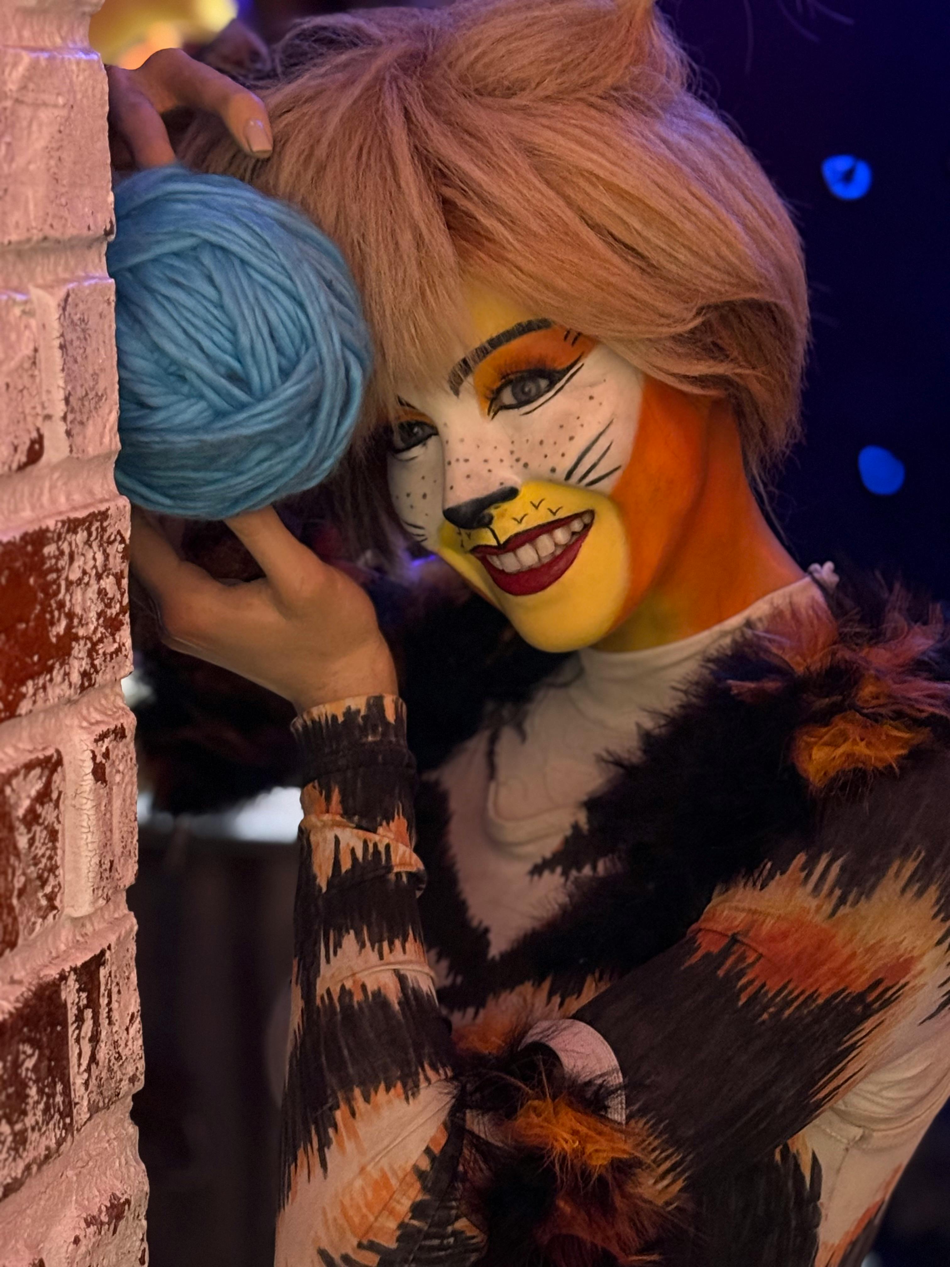 Free Vibrant portrait of a person in cat cosplay holding yarn indoors, in New York. Stock Photo