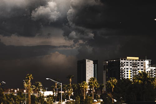 無料 迫り来る暗い雲の形成の下での都市の建物 写真素材
