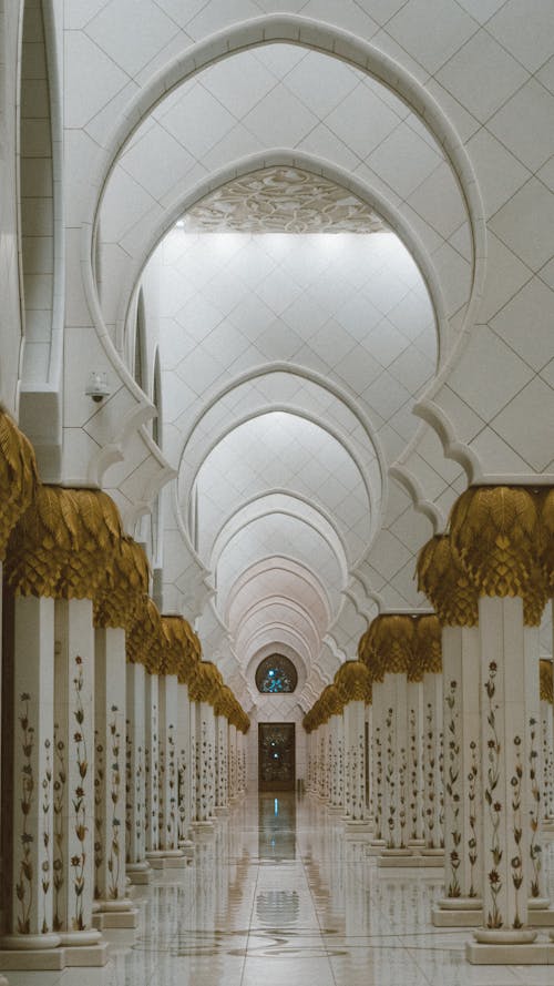 Free Intricately designed mosque corridor with arches and columns. Captures the essence of Islamic architecture. Stock Photo