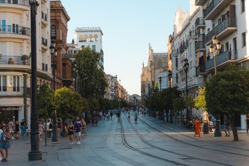 Free Vibrant day on a bustling street in Seville, showcasing the city's architecture and lively atmosphere. Stock Photo