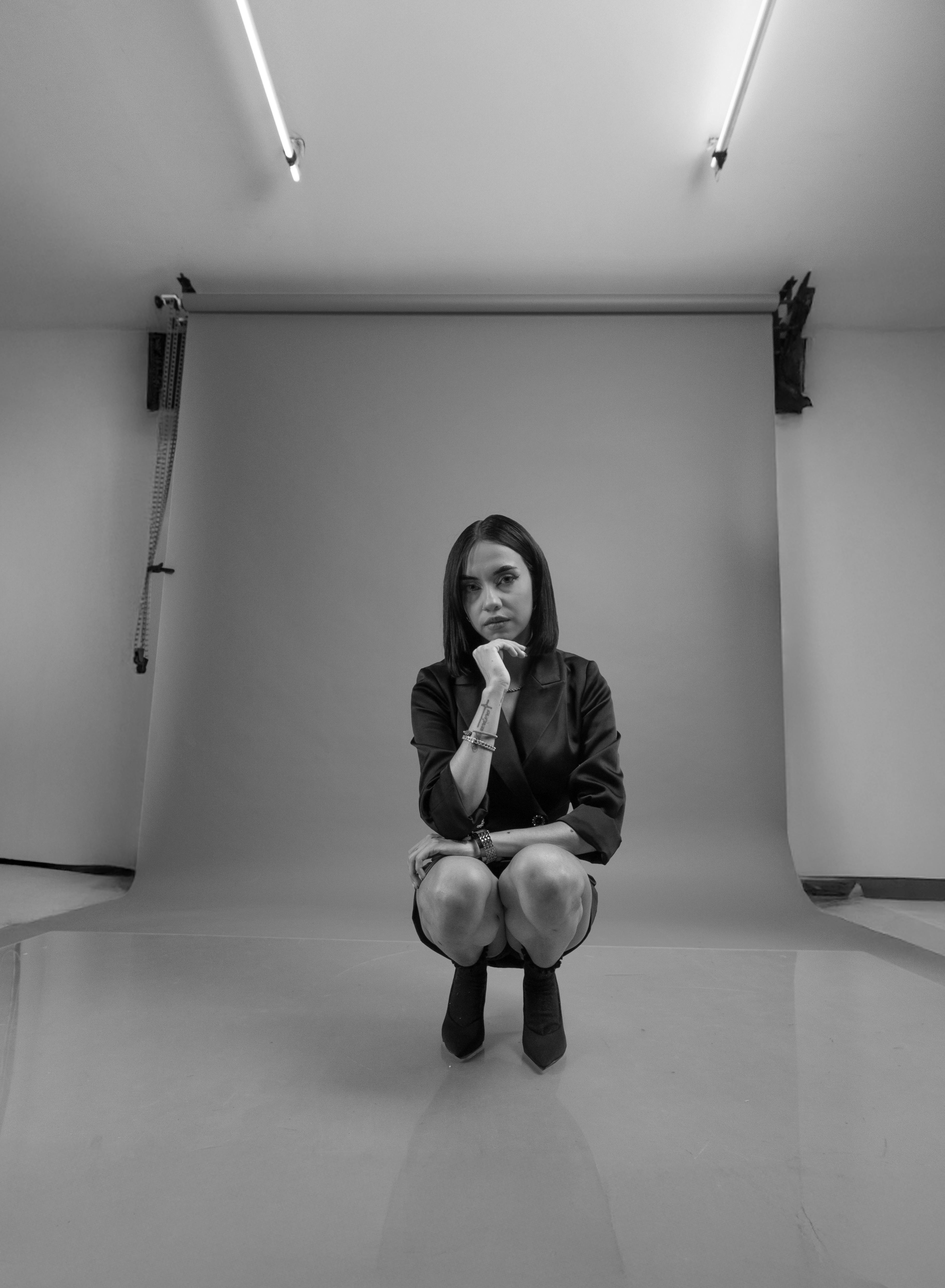 grátis Retrato elegante em preto e branco de uma mulher latina posando pensativamente em um estúdio. Foto profissional