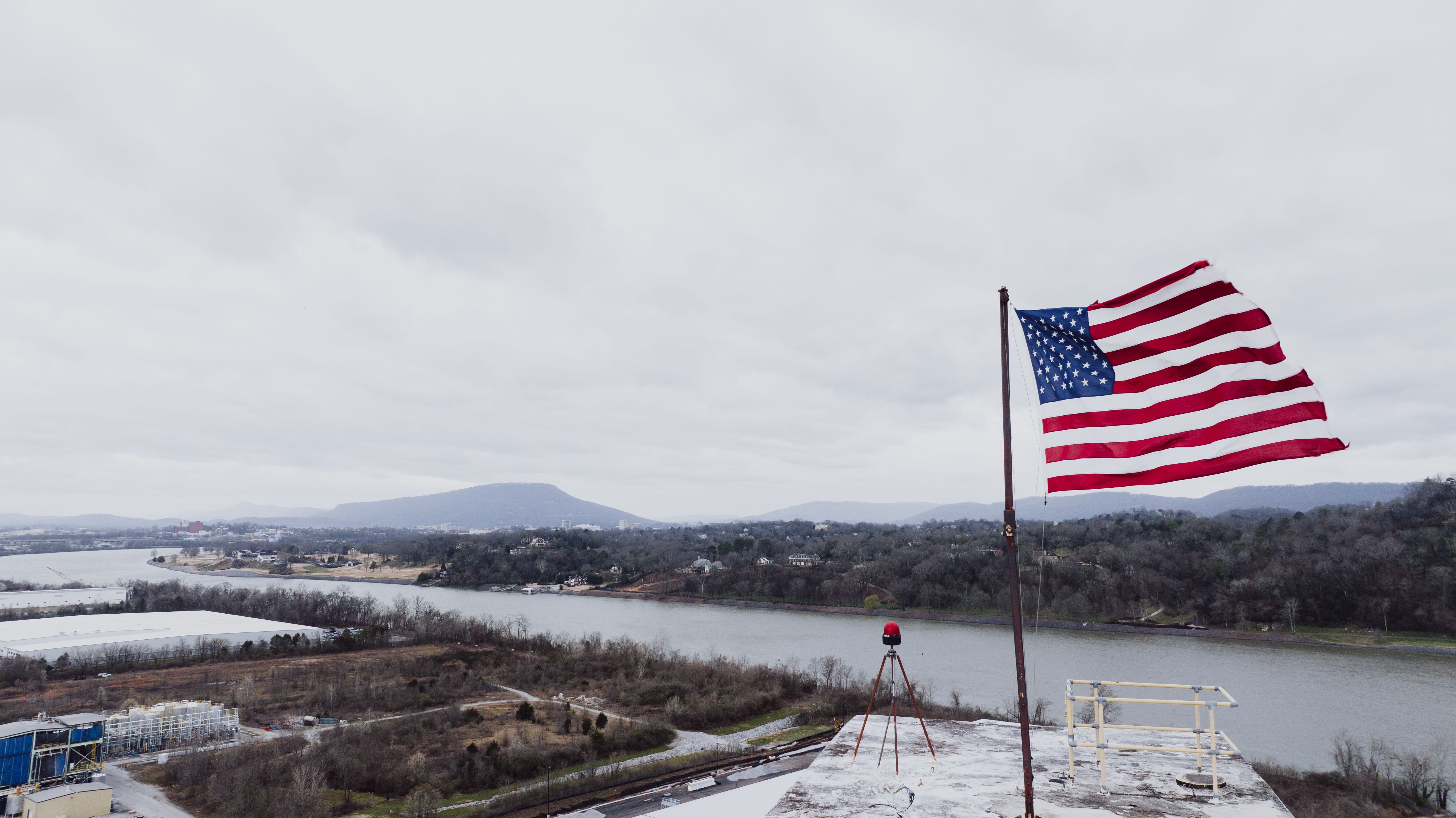 American flag waving above a scenic river in Chattanooga, Tennessee.