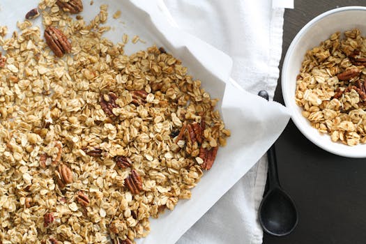Freshly baked granola with oats and pecans on parchment paper, perfect for a healthy snack.