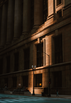 Charming play of light on historic building facade at dusk in urban street setting with vintage lamp post.