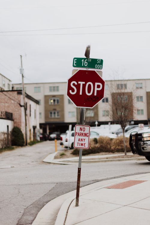 Free Leaning stop sign at E 16th Street, Chattanooga, capturing urban life. Stock Photo