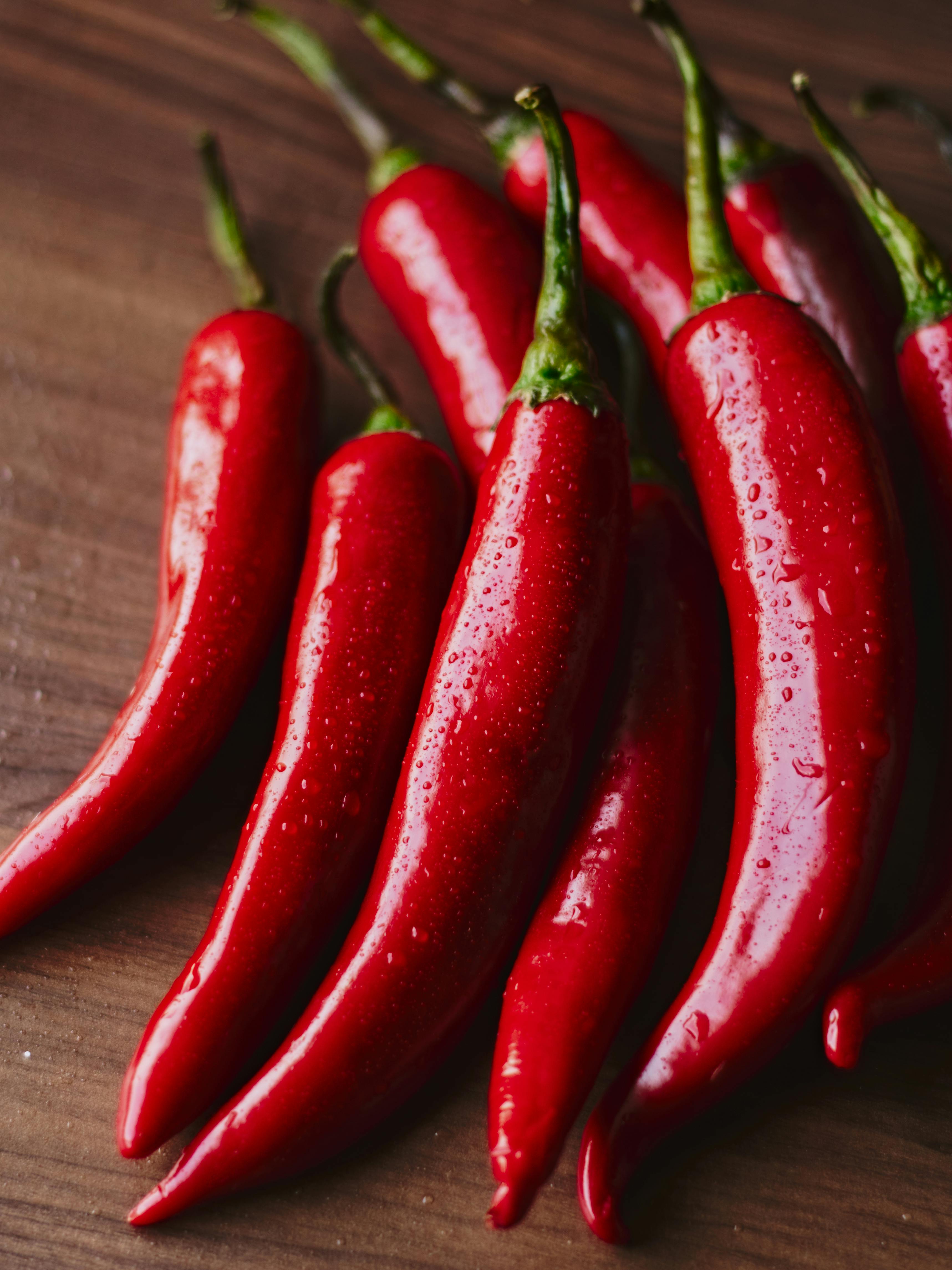 Close-Up of Fresh Red Chili Peppers on Wood · Free Stock Photo