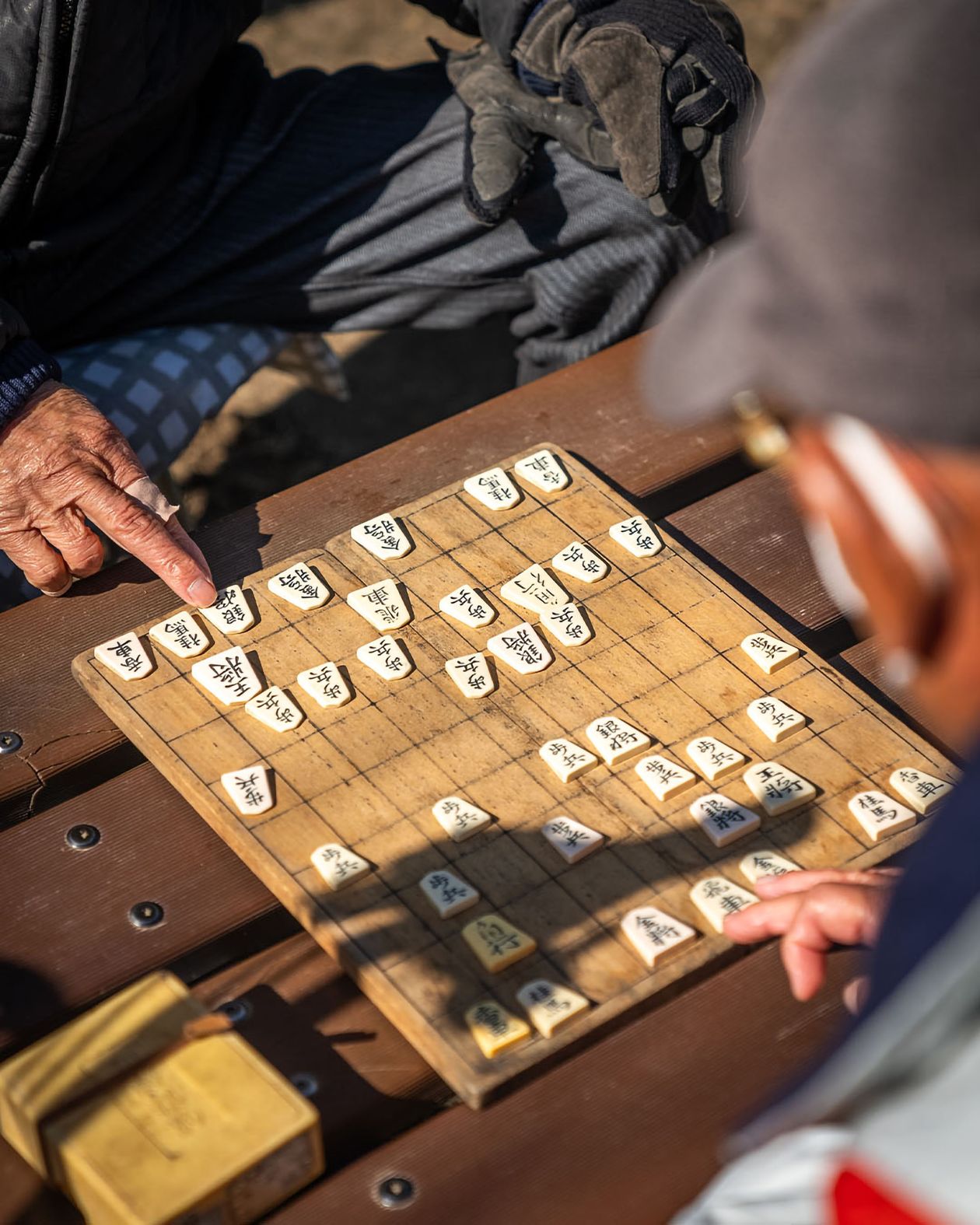 Hai người cao tuổi chơi cờ shogi ngoài trời