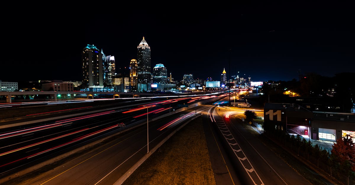 Vibrante fotografía nocturna del horizonte de Atlanta con cautivadores rastros de luz en una transitada autopista. Vibrante fotografía nocturna del horizonte de Atlanta con cautivadores rastros de luz en una transitada autopista.