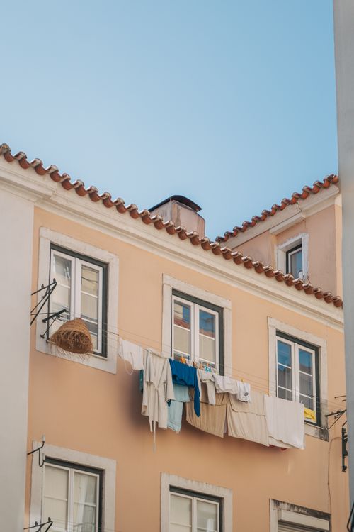 Free Charming urban scene of laundry hanging from a sunlit residential building facade. Stock Photo