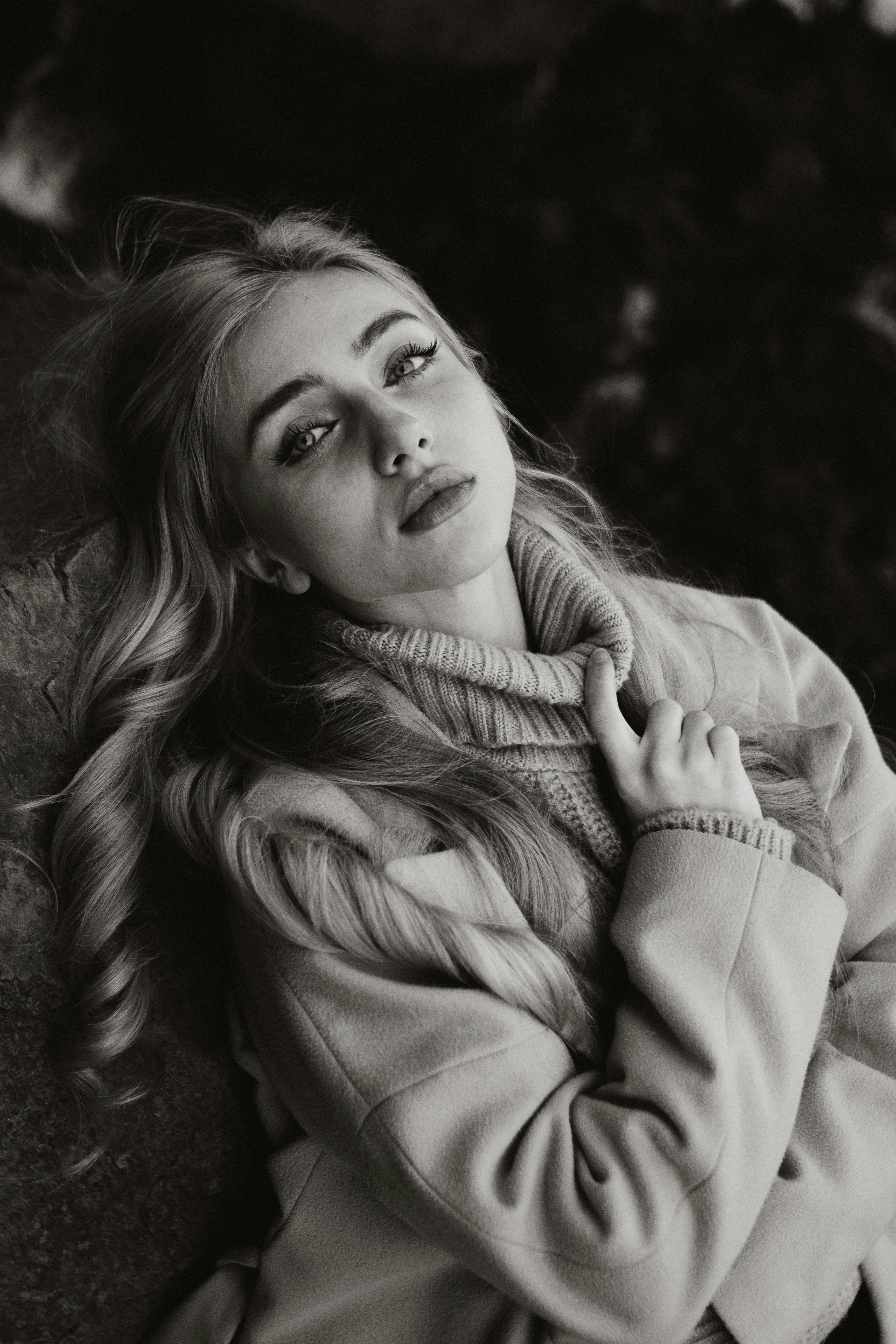 Elegant black and white portrait of a woman in a cozy setting.