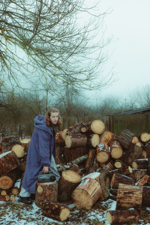 Young Woman Gathers Firewood in Winter Scene · Free Stock Photo
