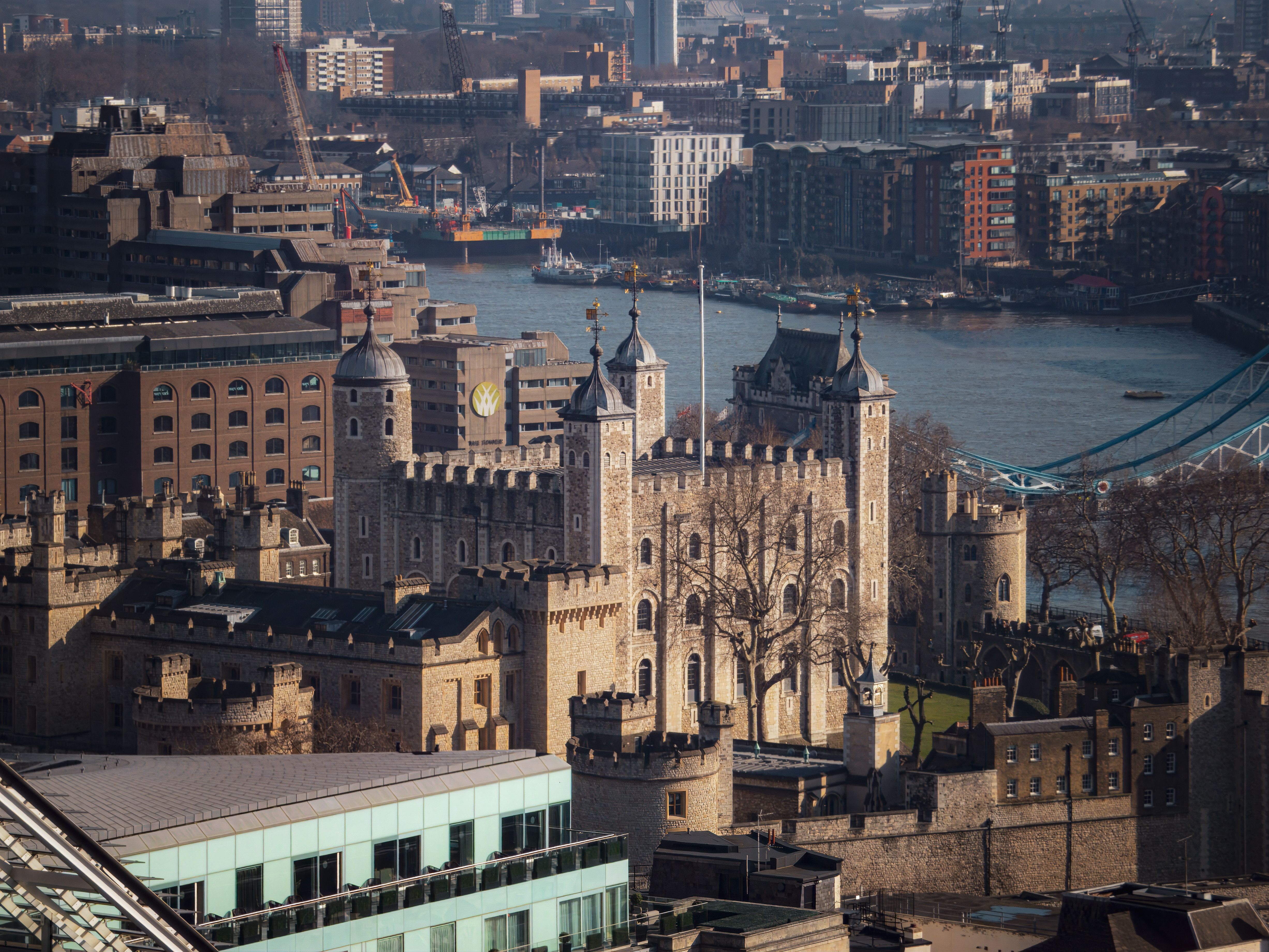 Aerial view of the historic Tower of London with urban skyline.
