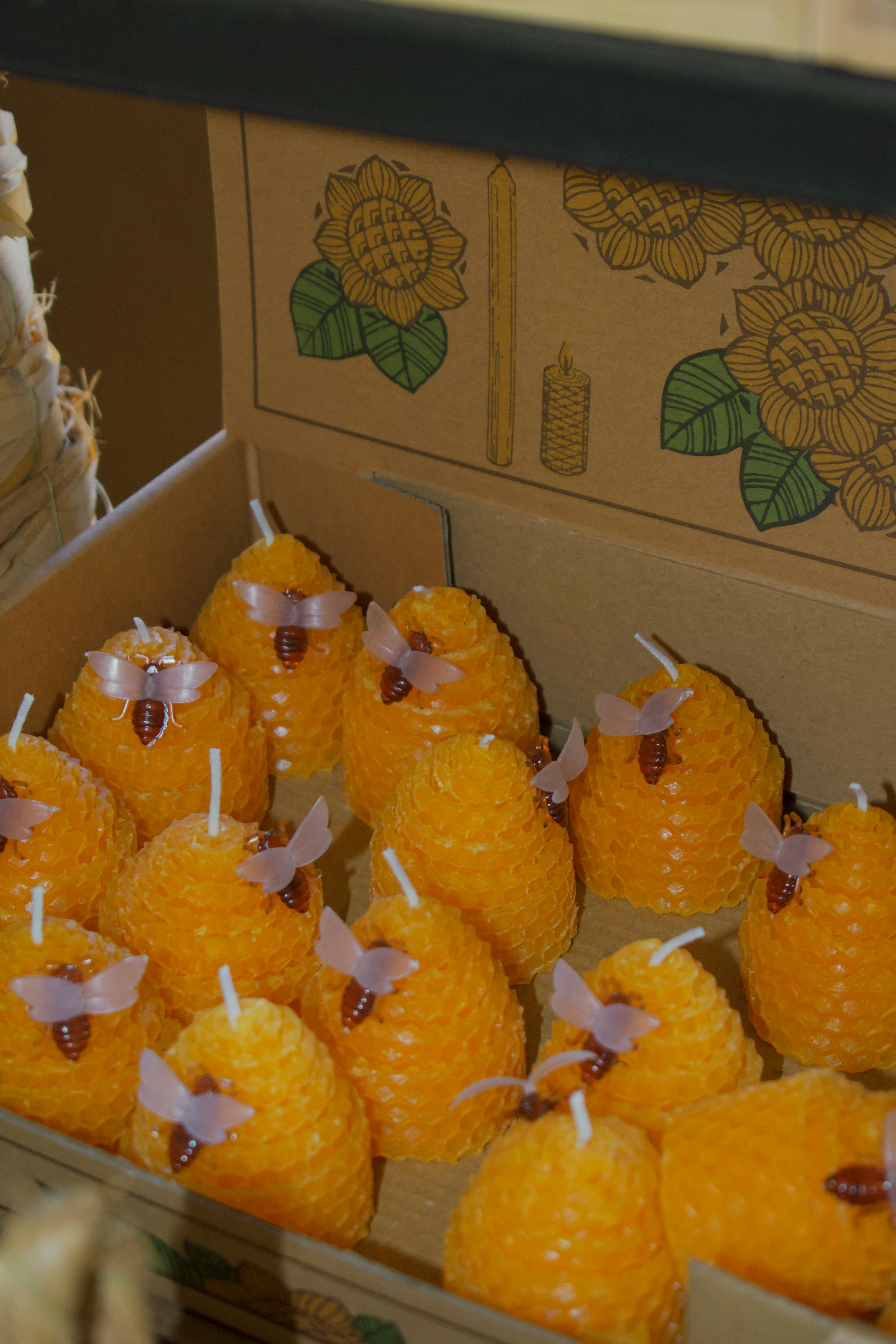Handmade beeswax candles with honeycomb texture and bee decor, perfect for gifts.