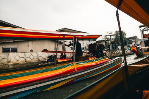 Free Vibrant longtail boats cruising a canal in Bangkok, Thailand. Explore local waterway life. Stock Photo