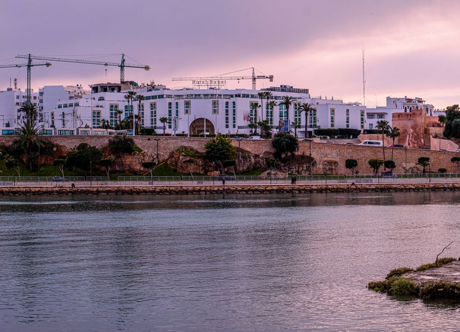 Scenic view of Rabat's architecture by the river at sunset.