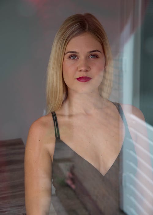 Photo of Smiling Woman in a Black V-neck Spaghetti Strap Top Posing