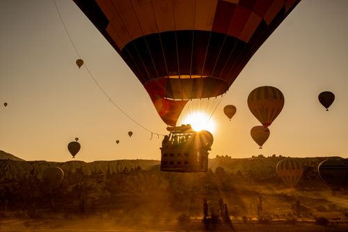 Free Scenic view of hot air balloons floating over Cappadocia, Turkey at sunrise. Stock Photo