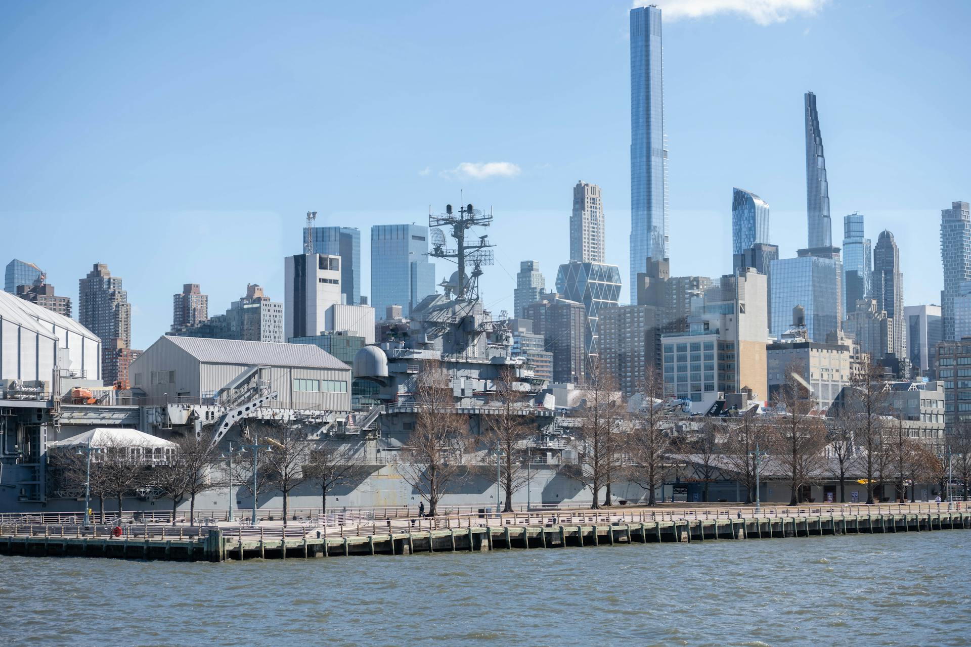 USS Intrepid museum ship with NYC skyscrapers in the background.