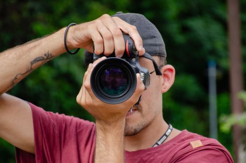Free A photographer focuses on the lens outdoors in Porto Feliz, Brazil. Stock Photo