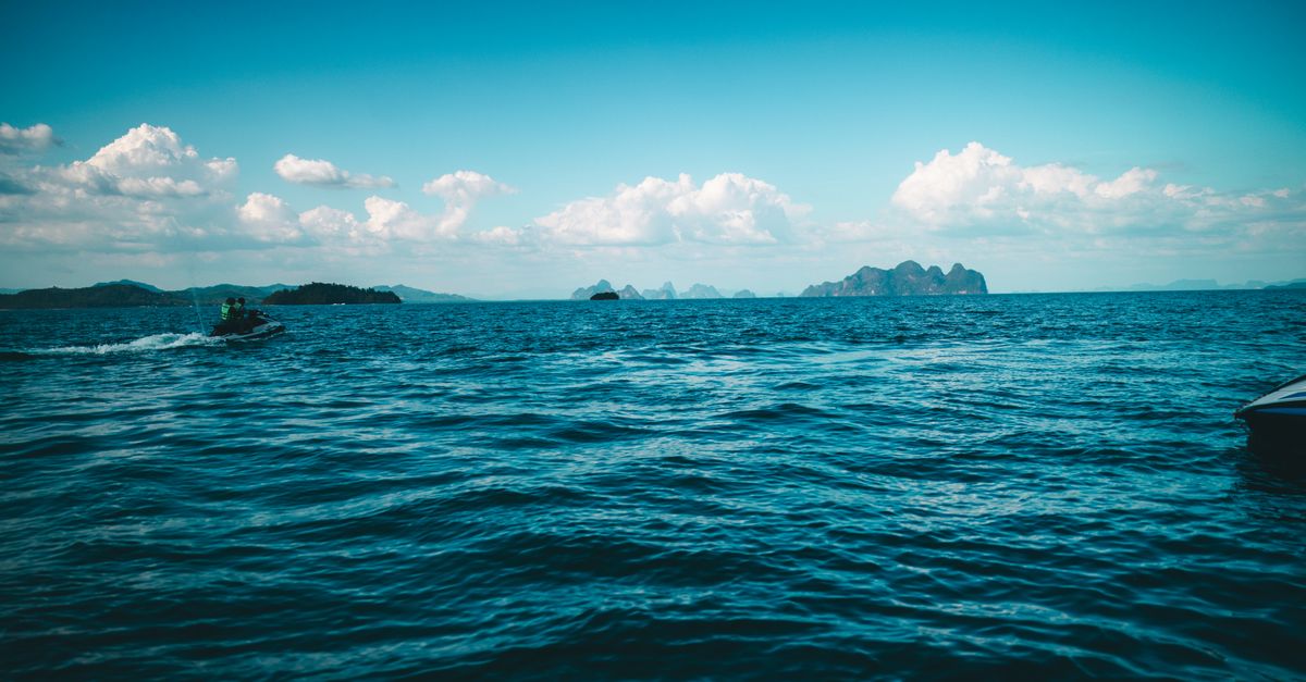 Vibrant seascape with distant islands and a jet ski in Phuket, Thailand.