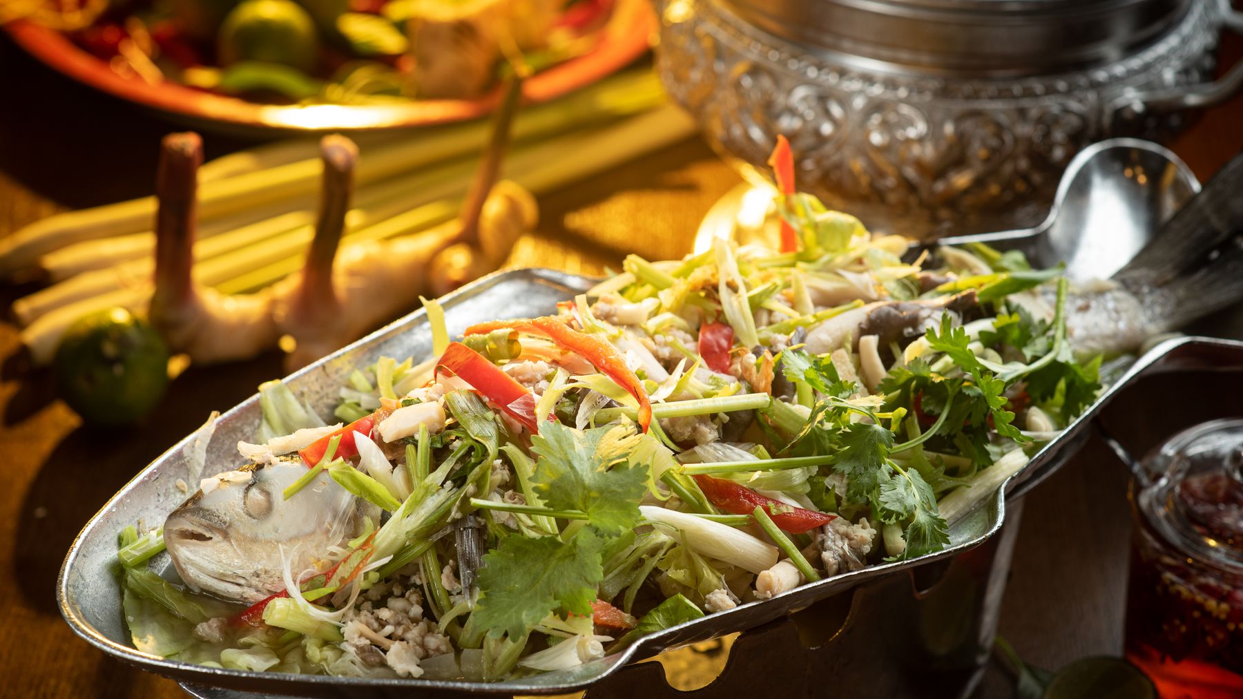 Delicious Thai steamed fish dish garnished with fresh herbs and spices.
