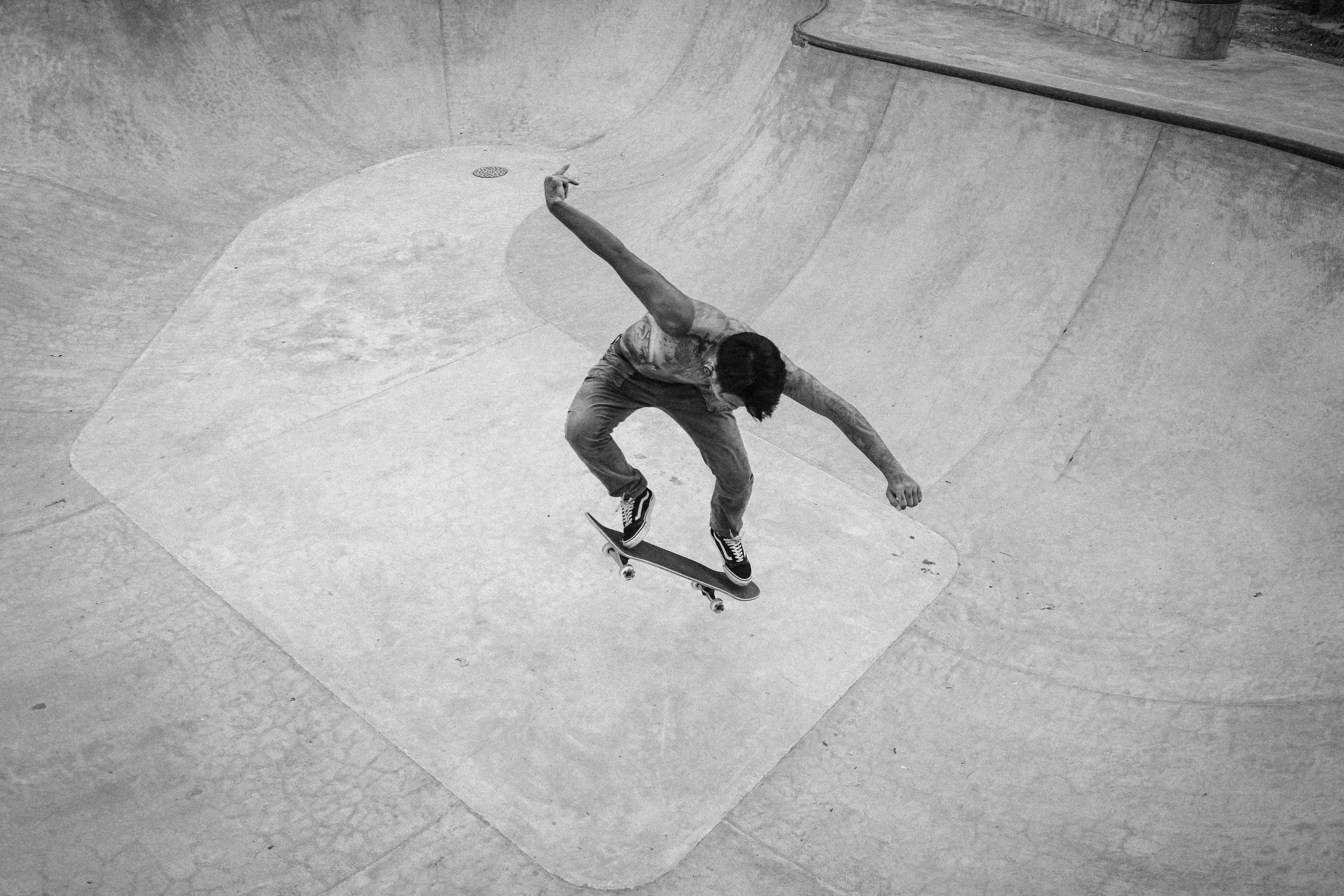 Houston skateboarder grinding concrete coping beside a weathered pool, gritty afternoon light and punk-inspired atmosphere