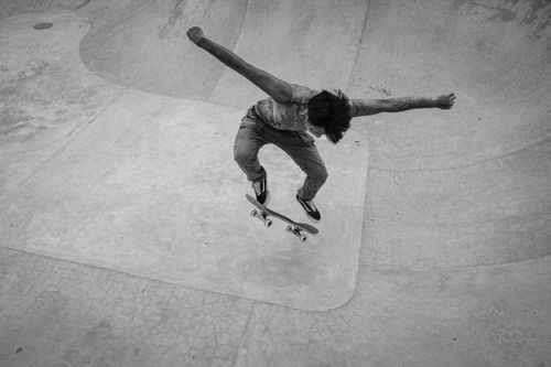 Free Black and white shot of a skateboarder performing an ollie at a skatepark in Bali, Indonesia. Stock Photo