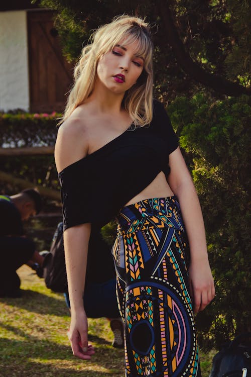Photo of Woman in Black Off-shoulder Crop-top and Multi-colored Pants Posing