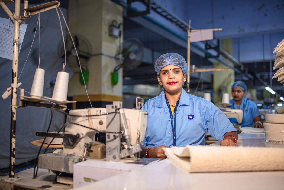Female workers sewing textiles in an Indian factory environment.