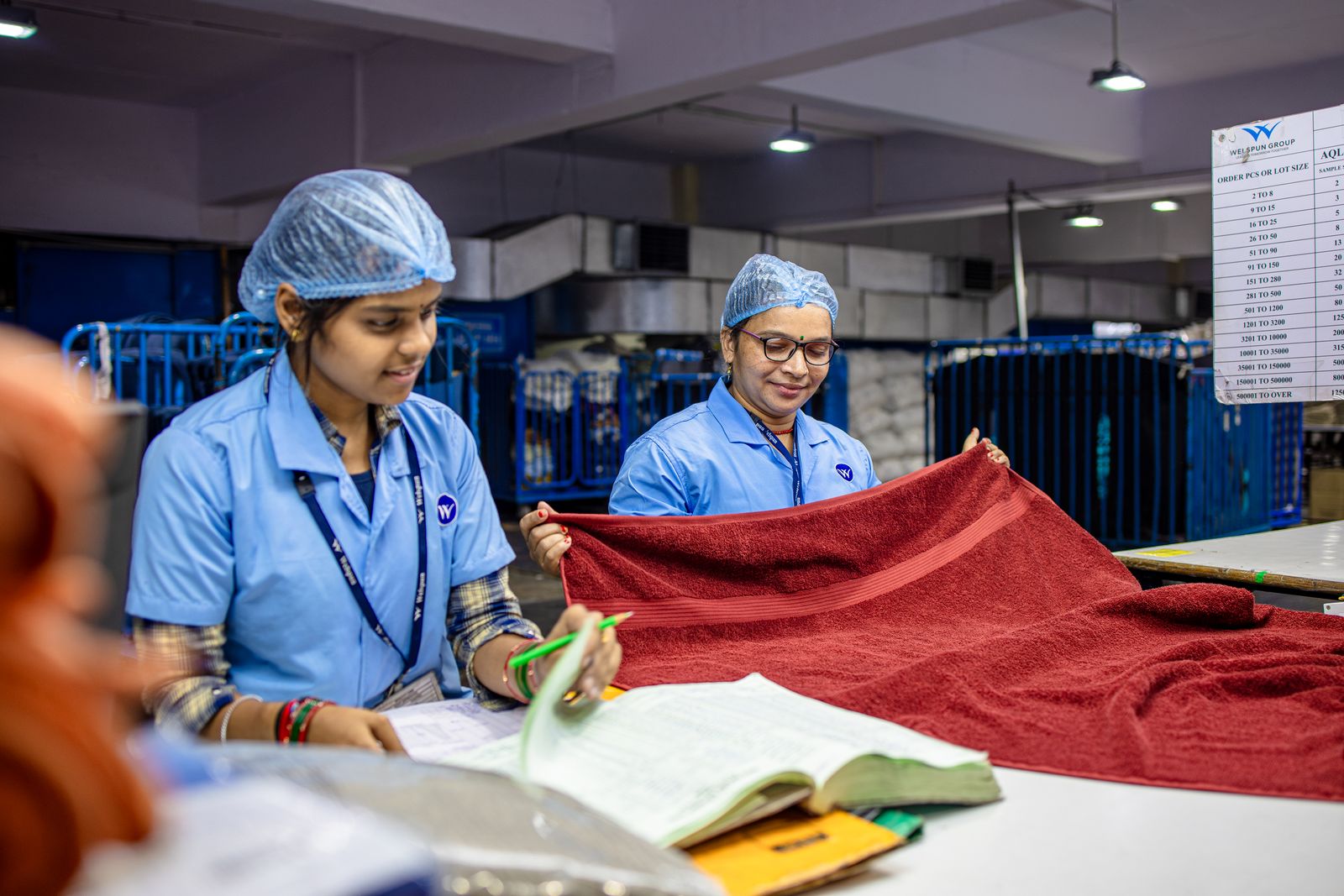 Two inspectors checking fabric against a checklist