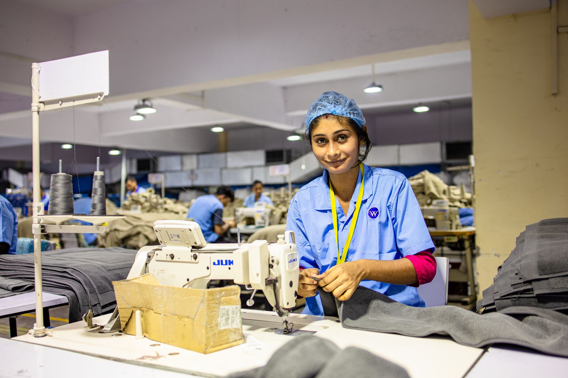 Female textile worker using a sewing machine in a garment factory