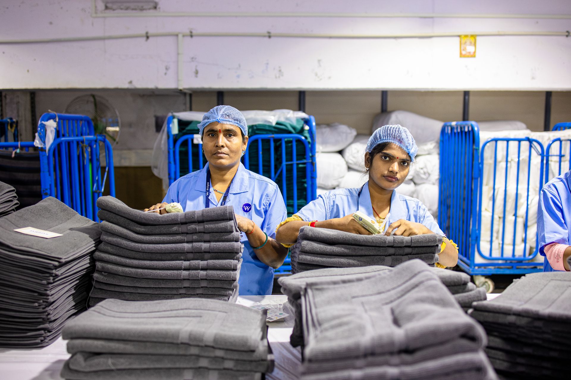 Textile factory workers sorting and folding fabrics with efficiency and focus, showcasing teamwork.
