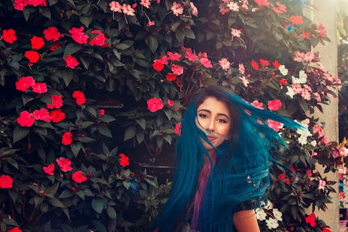 Photo Of Woman Standing Beside Flowers