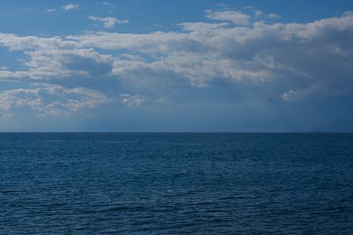 Free Tranquil ocean scene with a vast sky filled with clouds, offering a peaceful seascape view. Stock Photo