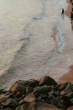 A tranquil scene of a beach with gentle waves lapping the shore at sunset, offering a peaceful ambiance.