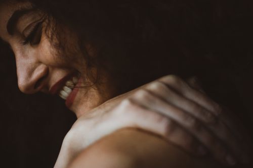 Free A joyful close-up portrait of a woman with a radiant smile and curly hair. Stock Photo