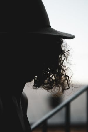 Backlit silhouette of a person in a wide-brim hat — photo by George Shervashidze on Pexels