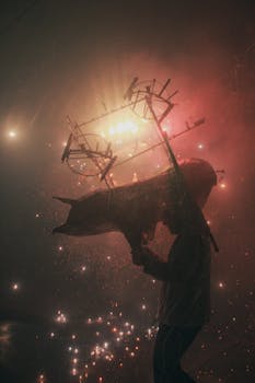 A dramatic silhouette holding a structure with explosive fireworks in a vibrant night festival setting.