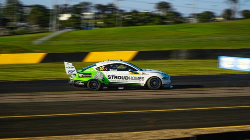 Free A sports car speeds down the racetrack at a vibrant outdoor setting. Stock Photo