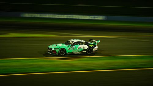 Free Green race car speeds on track at night, showcasing motor racing action. Stock Photo