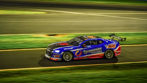 Free Dynamic shot of a racing car speeding on a lit track at night. Stock Photo