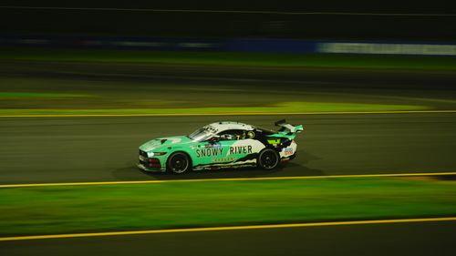 Free Vibrant race car speeding on track during night race, showcasing dynamic motion. Stock Photo