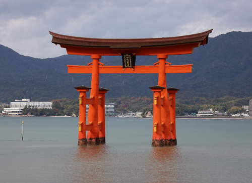 Free The famous floating Torii Gate at Itsukushima Shrine, set against mountainous backdrop. Stock Photo