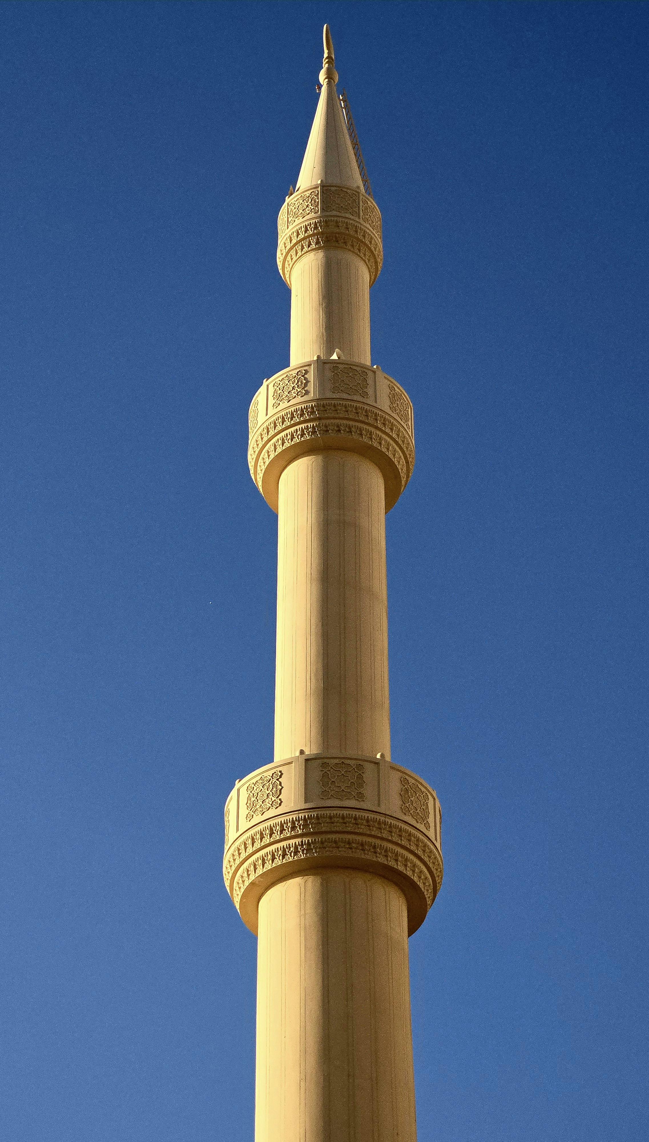 A stunning minaret reaching into a clear blue sky in Dubai, UAE.